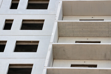 Future windows of a multi-story building under construction. Concrete structures. Industrial background.