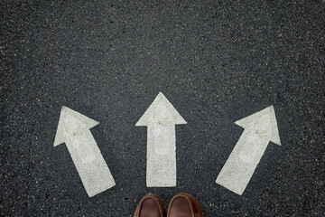 Foot of businessman step on 3 arrow direction; concept of decision 