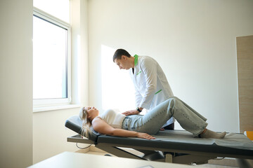 Healthcare professional performing abdominal palpation of female patient