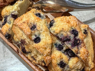 Blueberry scones on a tray with tongs