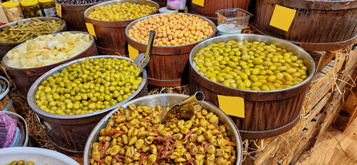 Varieties of olives in barrels in the delicatessen section