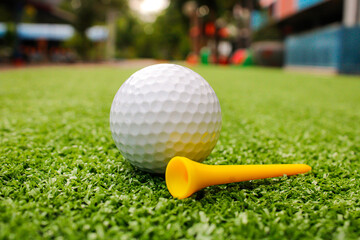 Golf balls and tees are placed on artificial grass.