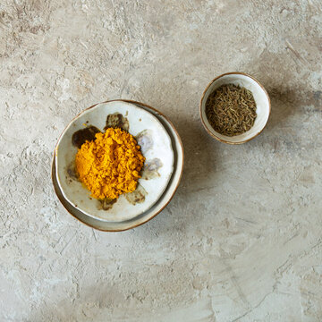 ceramic bowls with oriental spices: cumin and turmeric powder on the table
