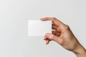 A hand holding an empty business card, close-up 