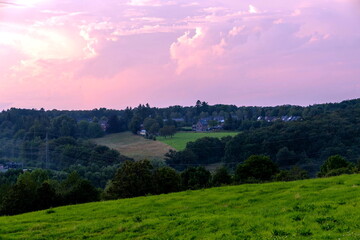 Abenddämmerung über blühenden Feldern zwischen Berg und Tal