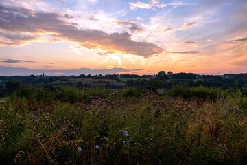 Abenddämmerung über blühenden Feldern zwischen Berg und Tal