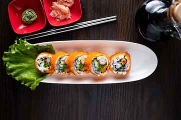 California Maki roll include rice, shrimp and lettuce leave with chopsticks served in dish isolated on wooden table top view of korean food