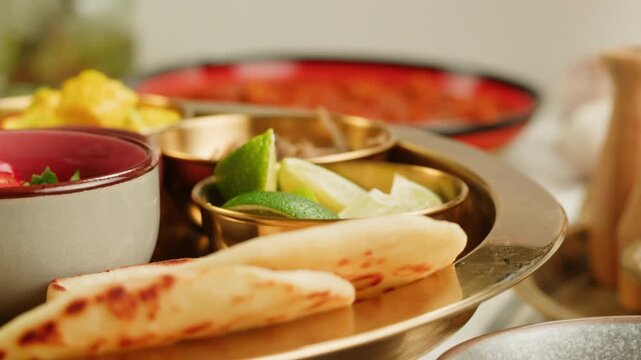 Assorted indian Sri Lankan food set on wooden background. Dishes and appetisers of indeed cuisine, rice, lentils, paneer, samosa, spices, masala. Bowls and plates with indian food top view chicken