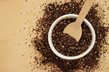 Fruit tea on the background of the table. Top view of tea in white dishes. Tea composition. Ingredients for a hot drink, close-up. Fruit tea, container and bamboo spoon on a light wooden background