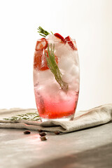 A drink with a lot of ice, red pepper, tomato and rosemary, mocktail, coffee on a beautiful, atmospheric summer day. White background and  copy space.