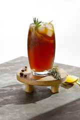 Cold refreshing coffee with tonic and rosemary and ice cubes on a beautiful sunny day, empty copy space for products.