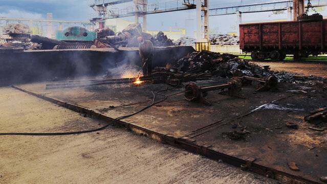A worker cuts metal with an autogen.