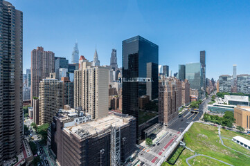 Obraz premium Stunning view of New York City skyline featuring iconic skyscrapers and modern architecture under a clear blue sky. Captures the vibrant urban landscape and architectural diversity. 