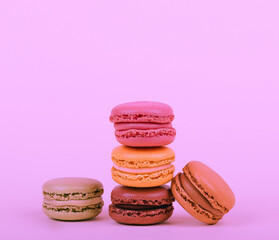 Colorful macaroons stacked on fuchsia bacground