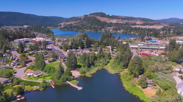 Aerial view of a lakeside town nestled amidst forested hills
