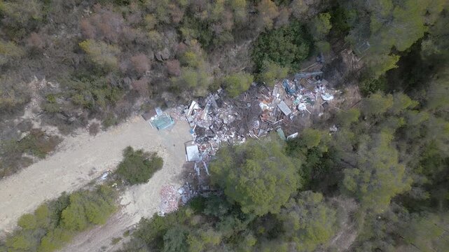 Un bosque con mucha basura y escombros esparcidos. La escena es de tristeza y desesperaci&oacute;n, ya que el bosque, anta&ntilde;o hermoso, ha sido destruido por los desechos humanos. 