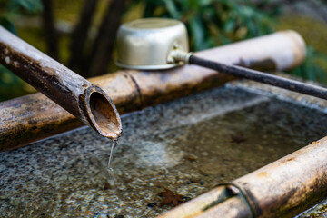 Japanese alms bowl in a Japanese garden with clean water flowing through bamboo tubes