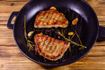 Roasted steaks with garlic, rosemary and spices in a cast iron grill pan