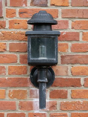 Black lamp on a house wall made of red bricks