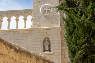 Fototapeta premium A niche with a sculpture of a Franciscan monk reading a sacred book, in the wall of a Franciscan monastery near Zion Gate of Jerusalem, Israel.