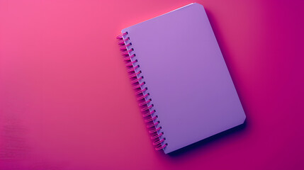 Purple notebook with spiral spring on magenta background viewed from above