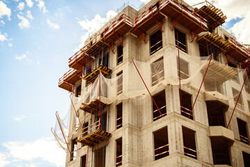 A building under construction with a protective net against falling objects from above