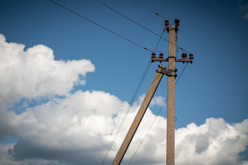 Concrete power line poles against a blue sky.