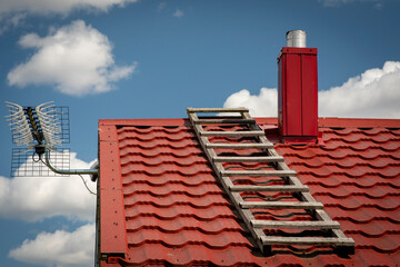 The roof of a house with a wooden ladder on it.