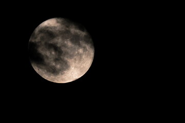 Full moon in the cloudy night sky