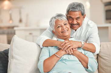 Obraz premium Portrait, love and senior couple in living room, smile and bonding of old man and woman with hug. Lounge, sofa and embrace of elderly people with commitment to marriage, care and support in house