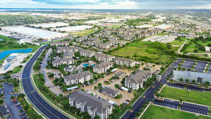 Industrial zone warehouse near brand new apartment complex with metal roofing in mater planned community in Pflugerville, fast-growing city suburbs of Austin, Round Rock metroplex, aerial view