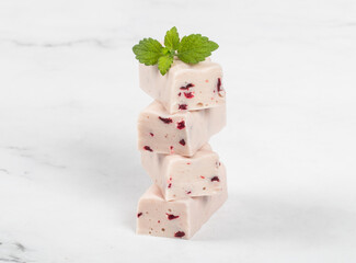 Cherry nougat with pieces of freeze-dried cherries. Decorated with fresh mint. Close-up