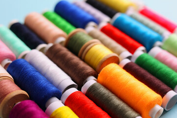 Threads for sewing in different colors on a colored background
