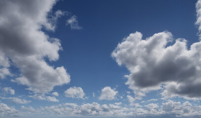 Wei&szlig;graue Wolken, die sich &uuml;ber den klaren, blauen Himmel erstrecken und eine leichte, luftige Atmosph&auml;re schaffen