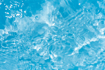 Blue water with ripples on the surface. Defocus blurred transparent blue colored clear calm water surface texture with splashes and bubbles. Water waves with shining pattern texture background.