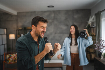 Close up of adult man sing karaoke on microphone at home