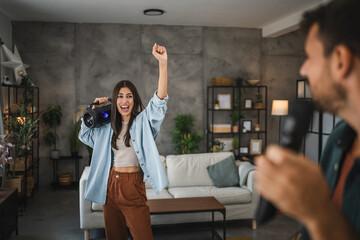 Fototapeta premium adult young woman dance with loudspeaker on karaoke party at home