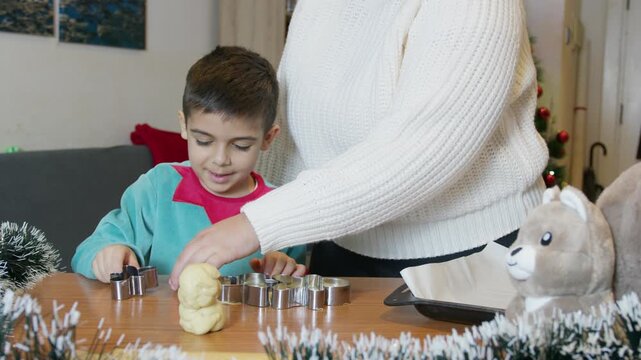 Mom and son making Christmas cookies together. Christmas holidaysand domestic life. Slow motion. High quality 4k footage