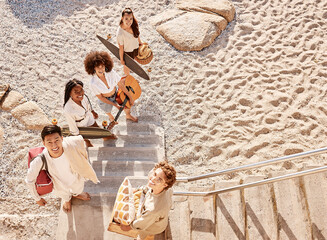 Fun, picnic and portrait of friends on beach together with guitar, skateboard and basket from...