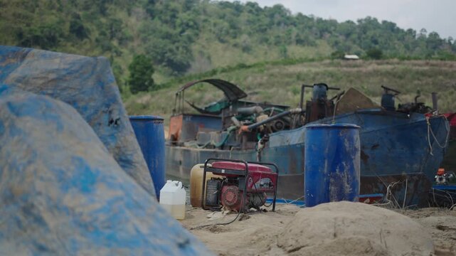 electricity generating generator set next to an old and rusty boat