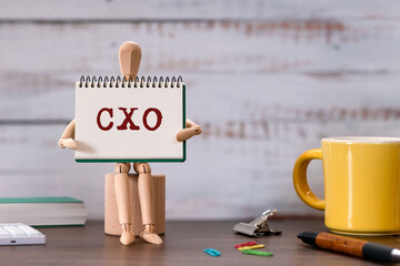 There is wood cube with the word CXO. It is an abbreviation for Chief user eXperience Officer as...