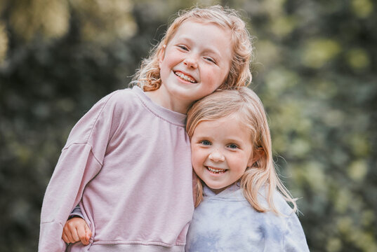 Outdoor, smile and siblings in portrait with hug, playful and bonding together with childhood games in park. Garden, children or girls with embrace for connection, development and caring in backyard