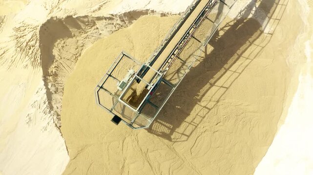 Stone crushing machine at open pit mining and processing plant for gravel stone. Fly over Rock and stone grinder and conveyor belt in a large quarry. 