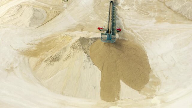 Stone crushing machine at open pit mining and processing plant for gravel stone. Fly over Rock and stone grinder and conveyor belt in a large quarry. 
