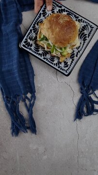 Vertical food video Cemita poblana on a talavera plate and a blue rebozo