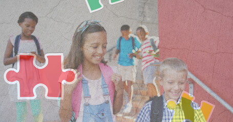 Jigsaw puzzle and human head icon over diverse group of students walking down the stairs at school