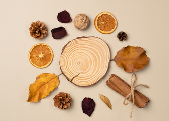 Autumn composition. Podium, pedestal, presentation empty mockup with leaves, nut, cones, dried fruits, cinnamon sticks on beige background. Top view, flat lay