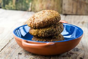 Oatmeal cookies in ceramic bowl on wooden background. Home cooking.