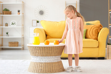 Cute little girl with oranges and juice at home