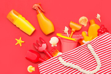 Beautiful composition with sunscreen and beach accessories for children on red background